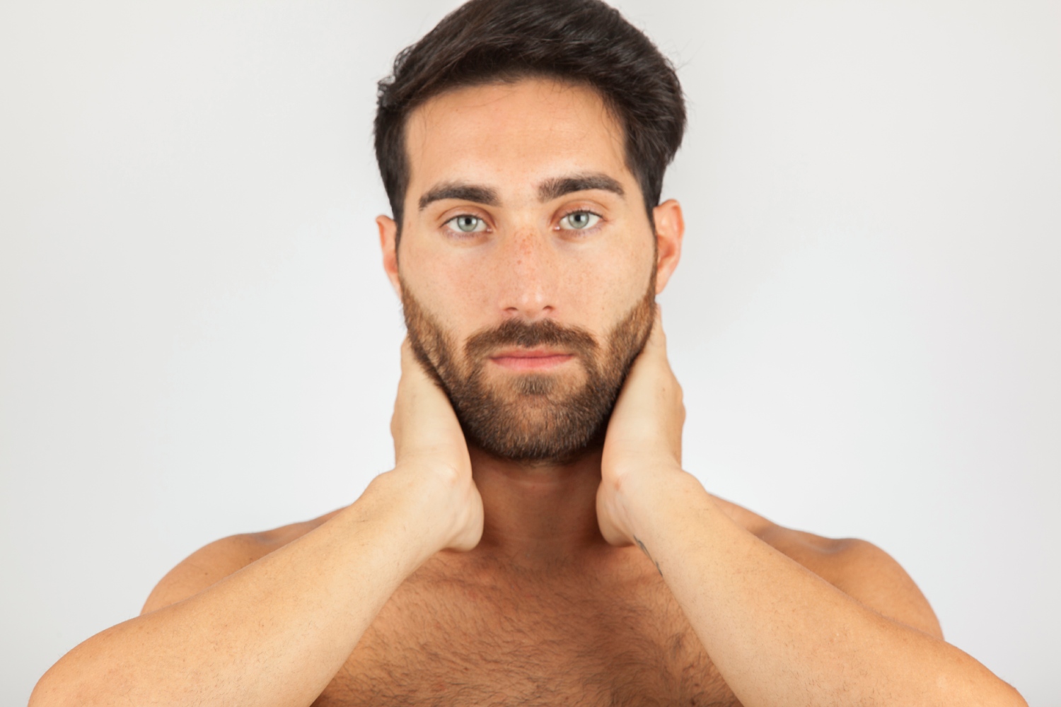 A male model checking his face after he got suboptimal facial implant results