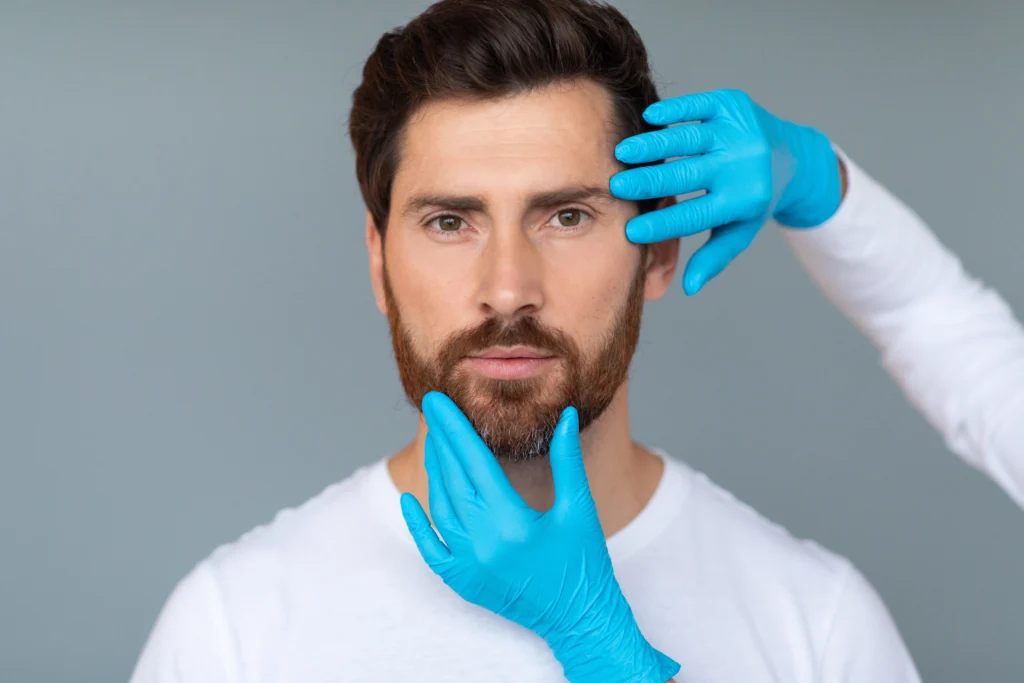 A plastic surgeon examining patients face before facial implant.